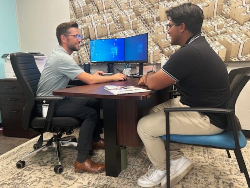 Mark Koepf, vice president and director of government guaranteed lending for University Bank, helps a client at University Bank's new Ypsilanti branch.