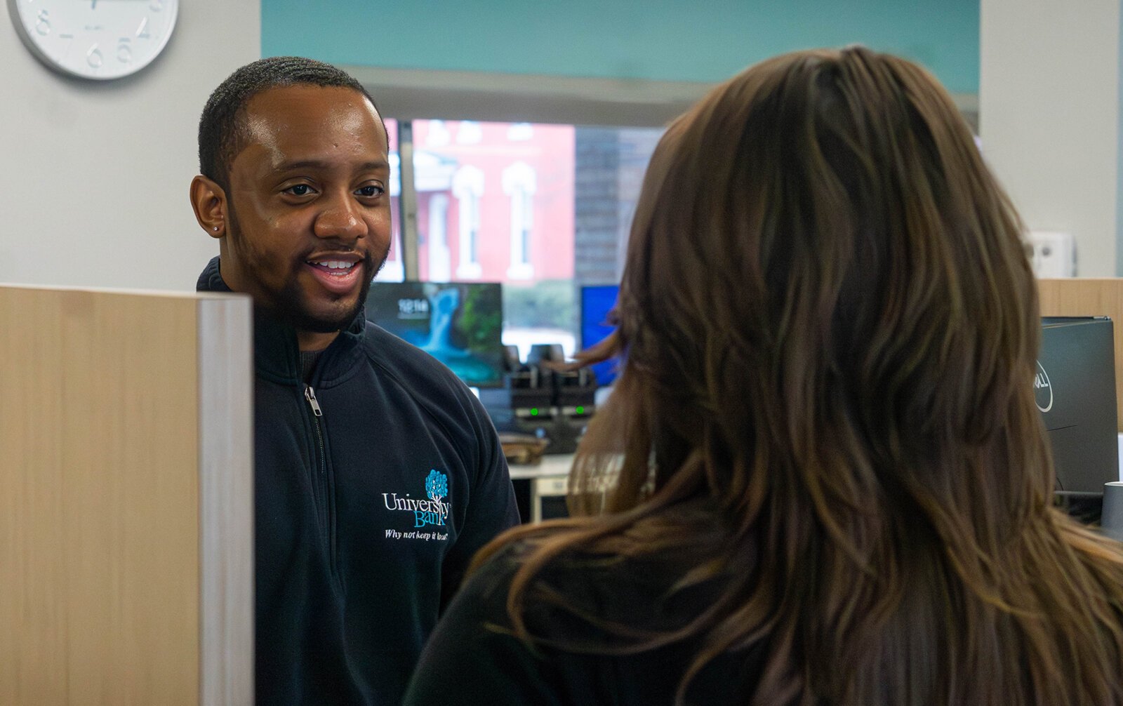 Jeremiah Muhammed, senior customer service representative at University Bank, talks to Jori Knight, customer service supervisor at University Bank.