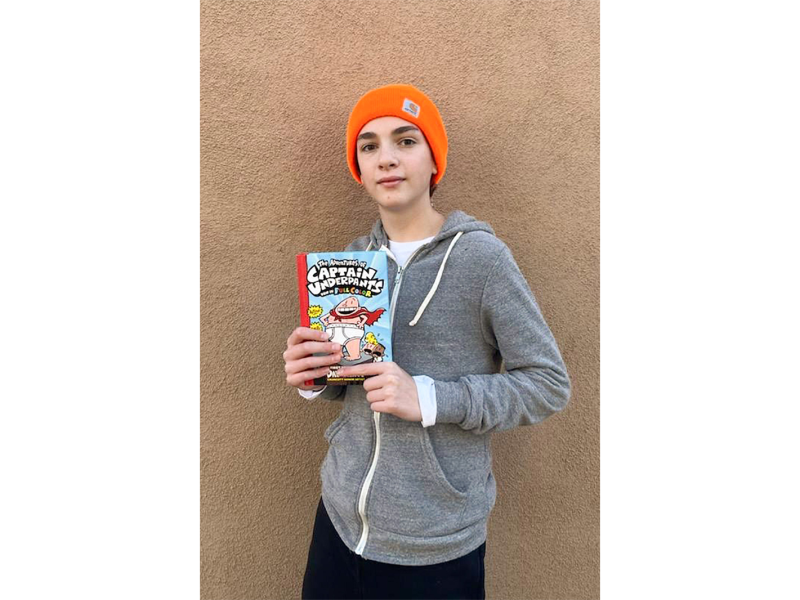 Student Elijah Wynn with one of his favorite books from the "Captain Underpants" series. The series has been frequently banned across the U.S.