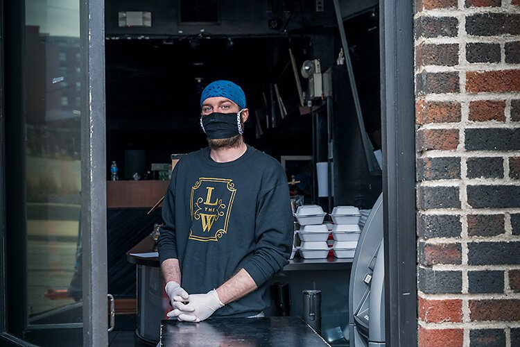 Nathan Coleman, head chef at Ann Arbor's The Last Word, hands out Service Industry Family Meals at LIVE in Ann Arbor.