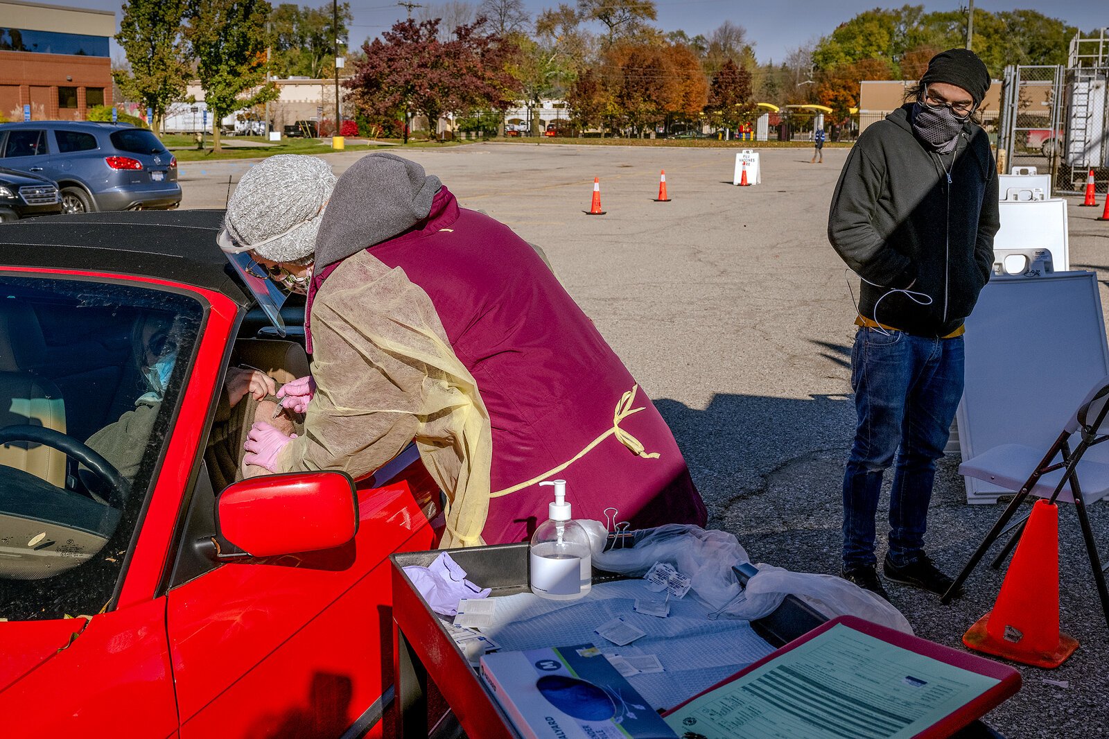A drive-through flu vaccine is administered in the Washtenaw County Health Department parking lot in Ypsilanti.