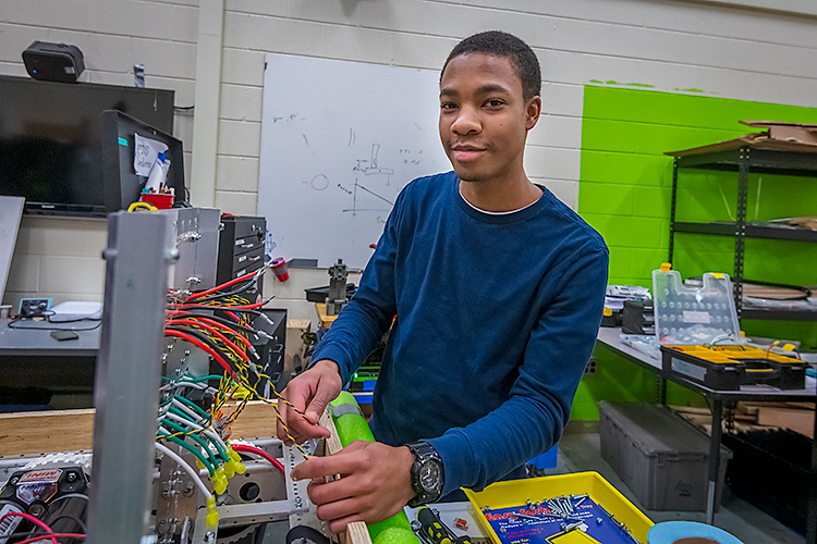 Austin McDonald working on a robot with Lincoln High School's Linc-Bots team