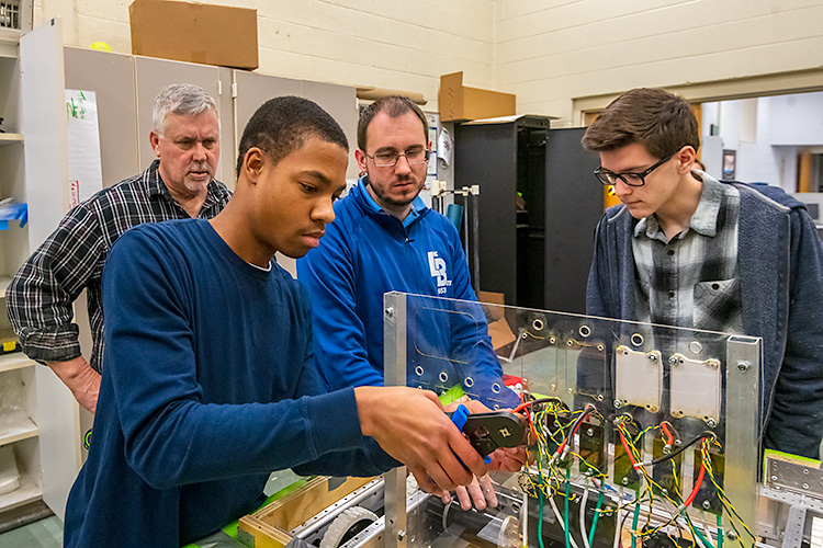 Austin McDonald working on a robot with Lincoln High School's Linc-Bots team