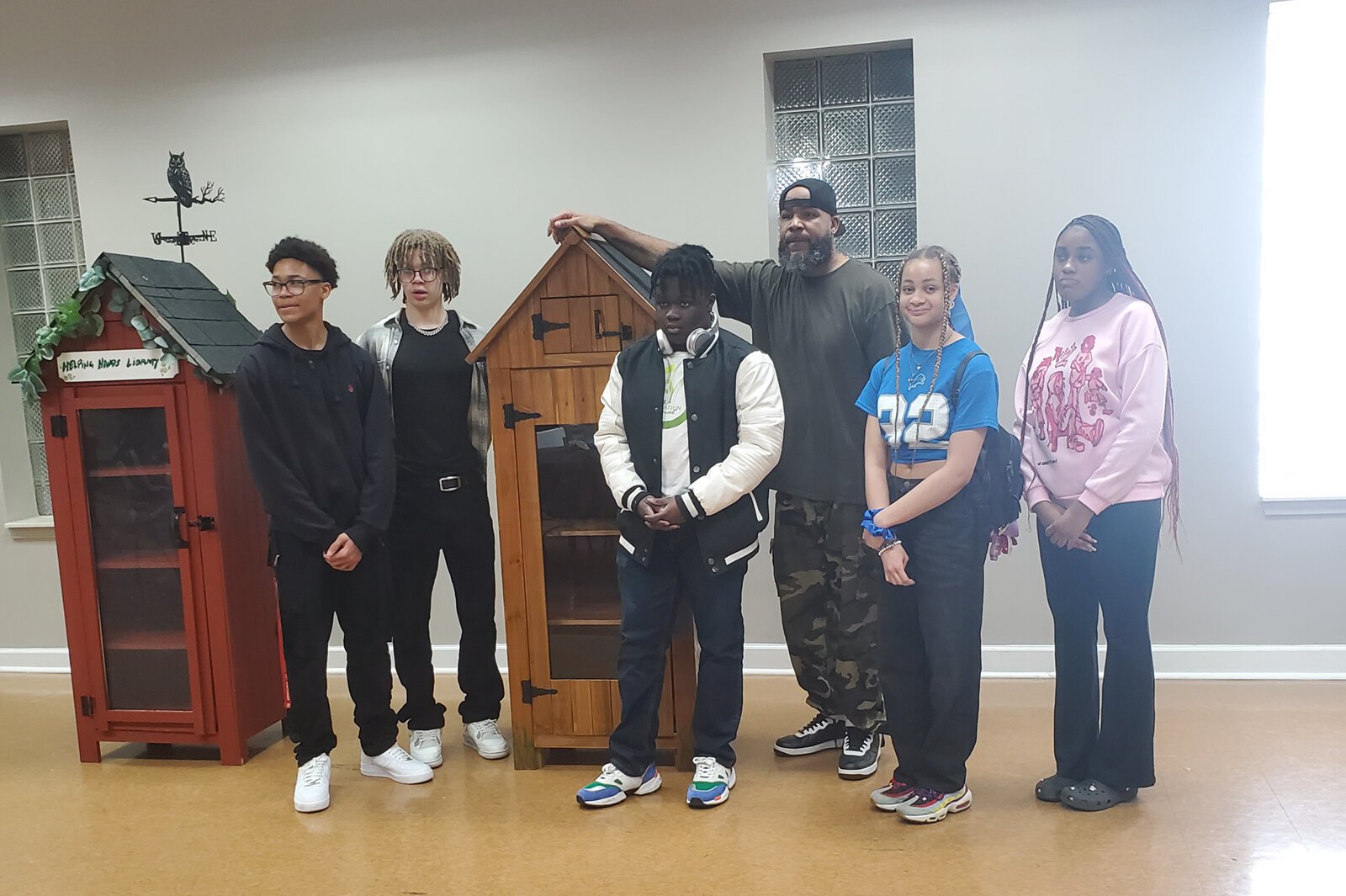 TradeScouts program participants and leaders pose with small sheds they built to be used as Little Free Libraries and mini-food pantries.