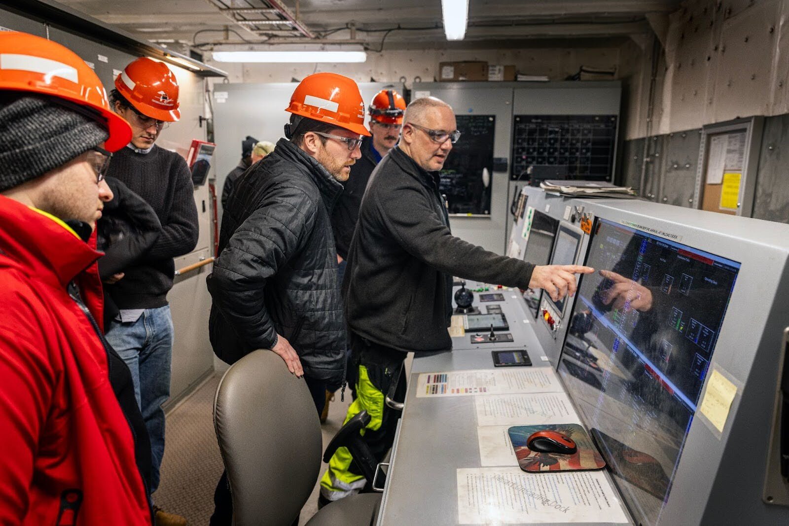 Chief engineer Erik Wlazlo (first right) shows Thomas McKenney (center) and his students, Logan Cox (back left) and Hal Berdichesky (front left), how the engine control room works on the Mark W. Barker.