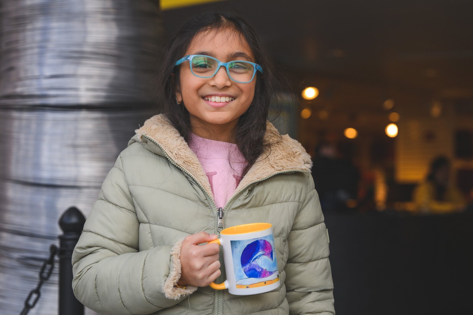 Doodles Academy past participant Swara Goyal holding a mug with her artwork that she was awarded.