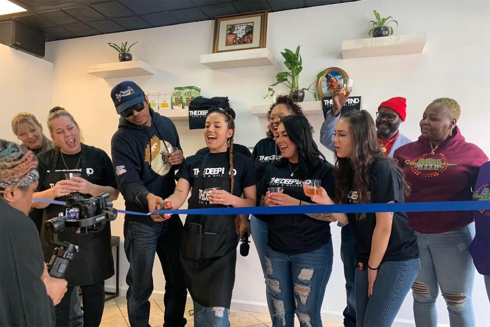 The Deep End Cafe owner Candace Cavazos (center with scissors) at the ribbon cutting for the opening of The Deep End Cafe.