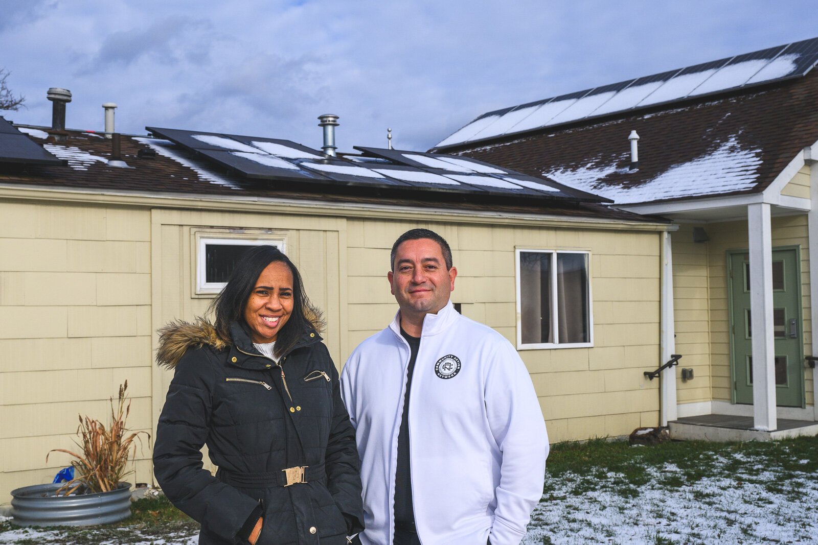 Krystal Steward and Derrick Miller in front of the solar panels on Bryant Community Center.