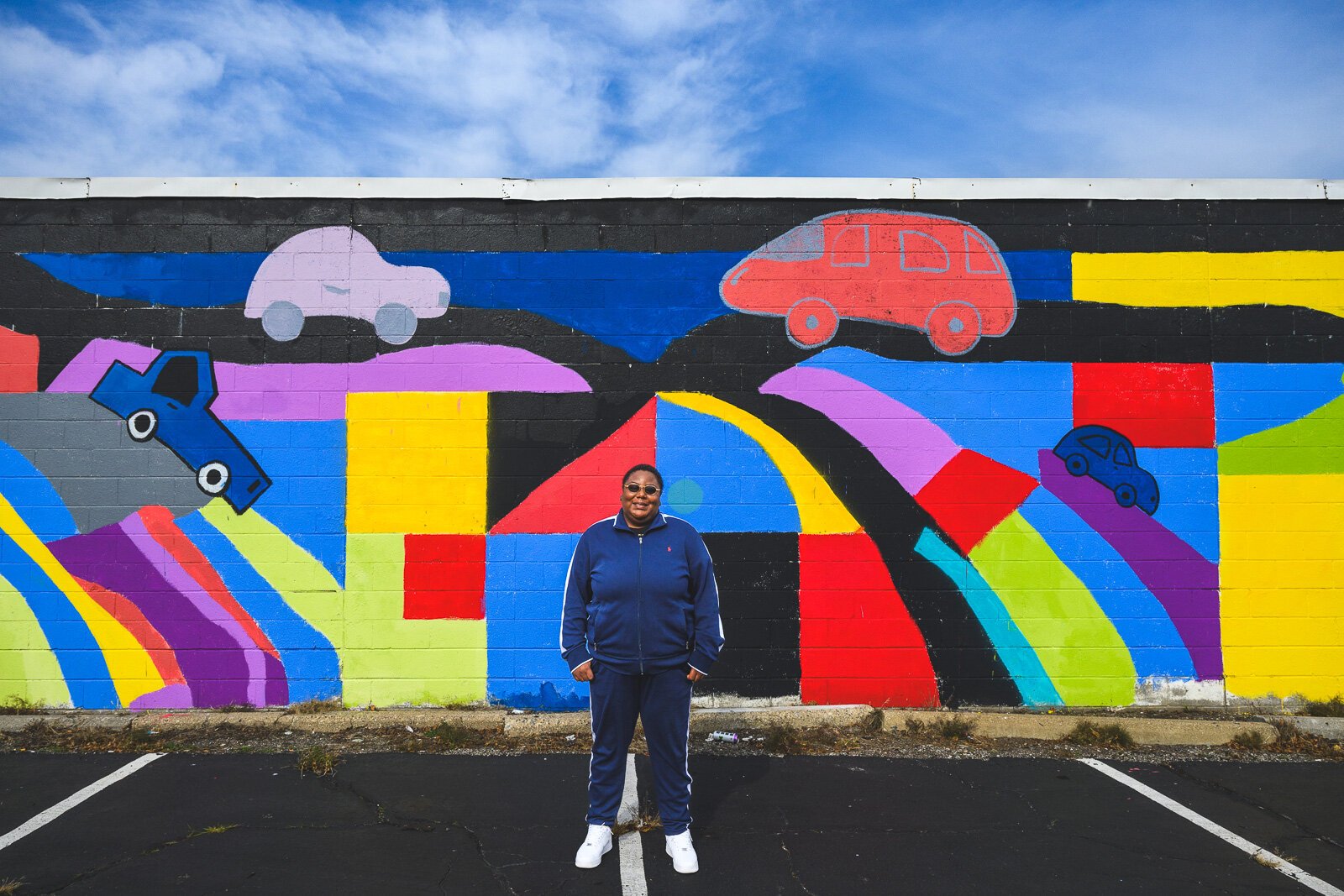 Youth Art Gallery Executive Director T'Onna Clemons in front of the Youth Art Gallery mural at Community Auto Wash.
