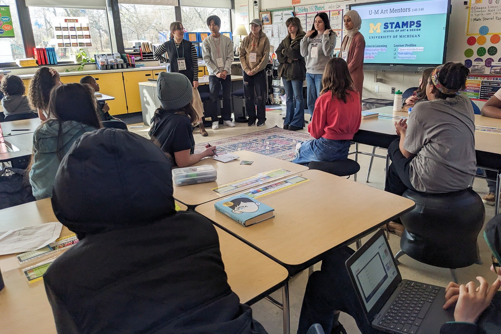 Stamps School students helping YIES students work on artwork for their capstone projects.