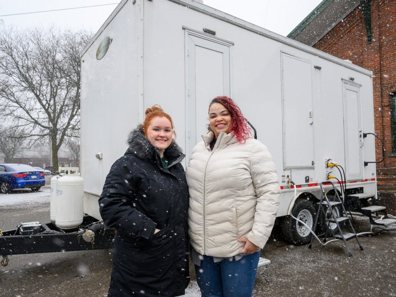 Kate Holcomb and Tajalli Hodge with the WashUp Ministries mobile shower facility at the Ypsilanti Freighthouse.