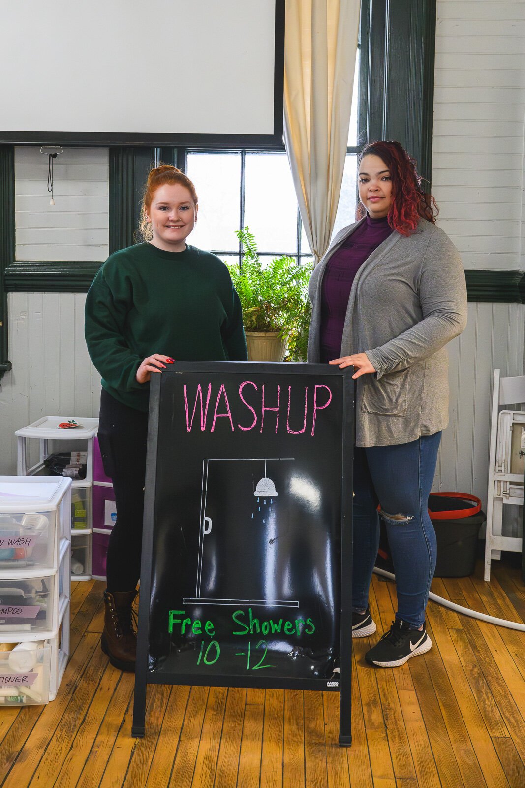 Kate Holcomb and Tajalli Hodge with the WashUp Ministries mobile shower facility at the Ypsilanti Freighthouse.