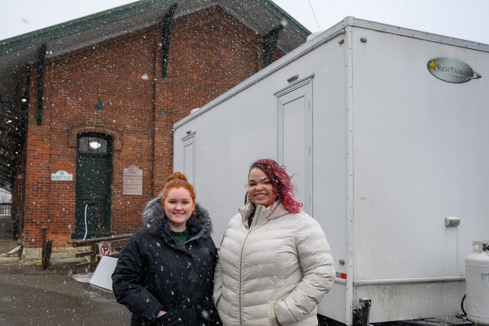 Kate Holcomb and Tajalli Hodge with the WashUp Ministries mobile shower facility at the Ypsilanti Freighthouse.