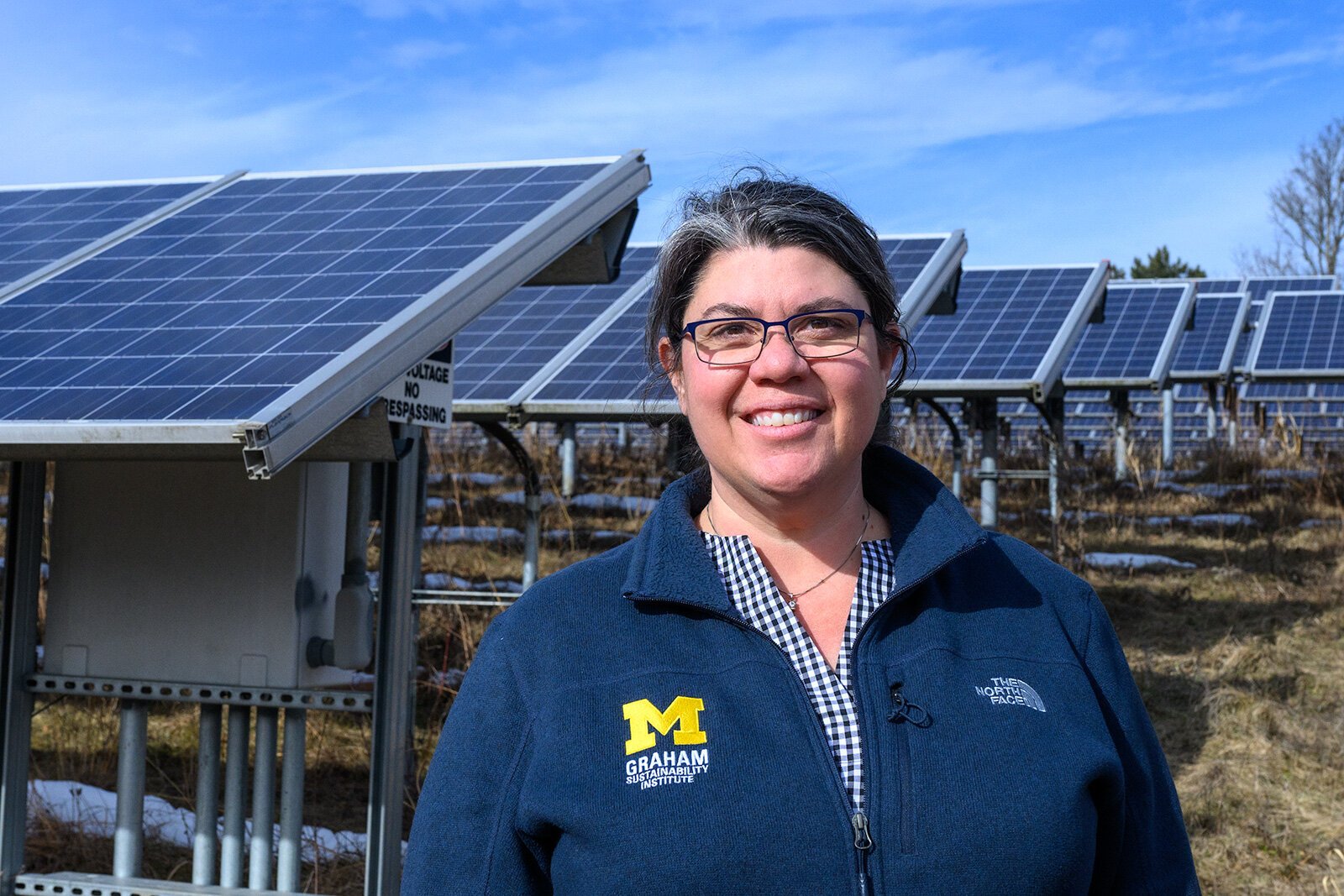 Sarah Mills in front of solar panels on U of M's North Campus.