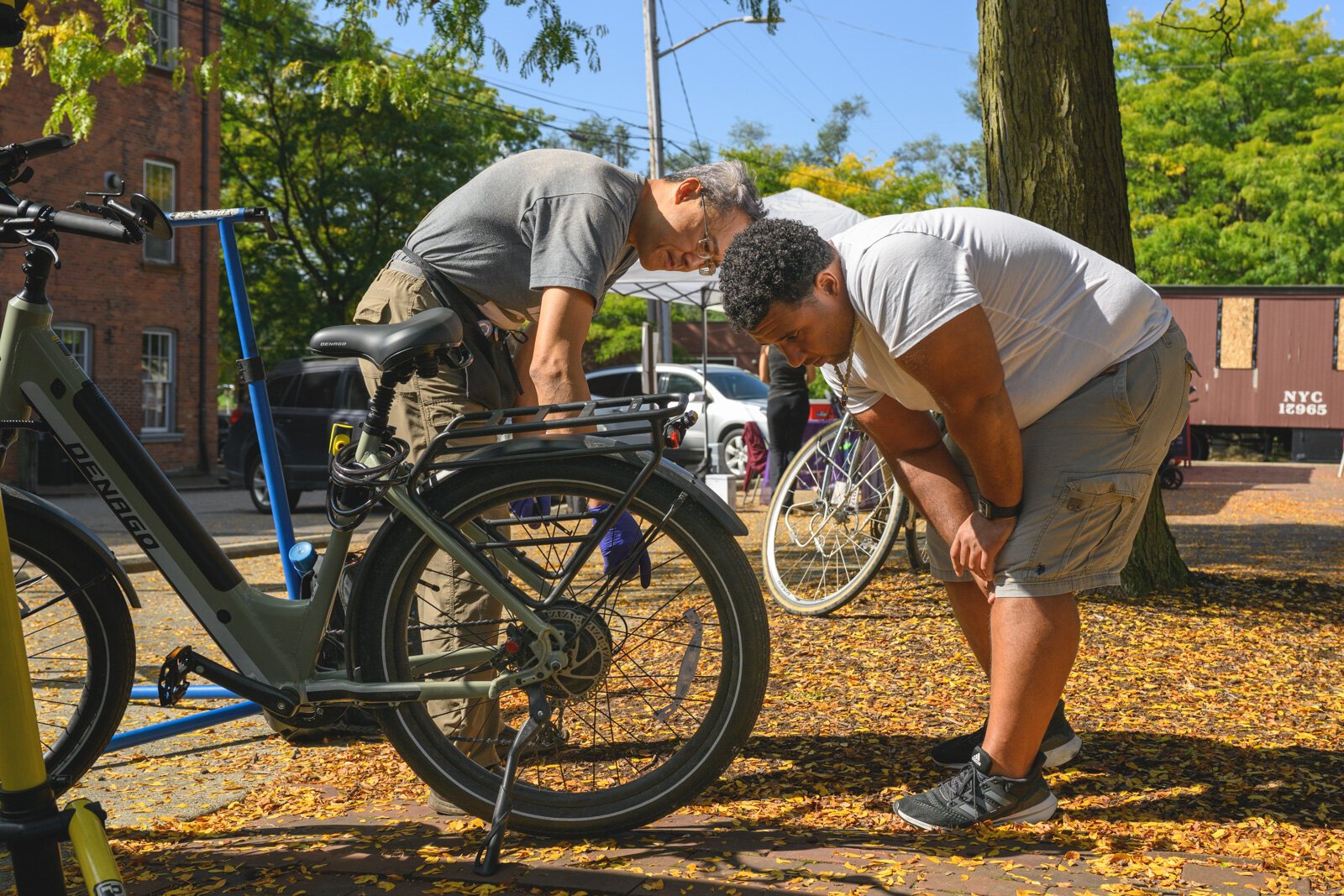 Yitah Wu repairing a bike at the Ypsi Bike Co-op's booth at Ypsilanti's Depot Town farmers market.