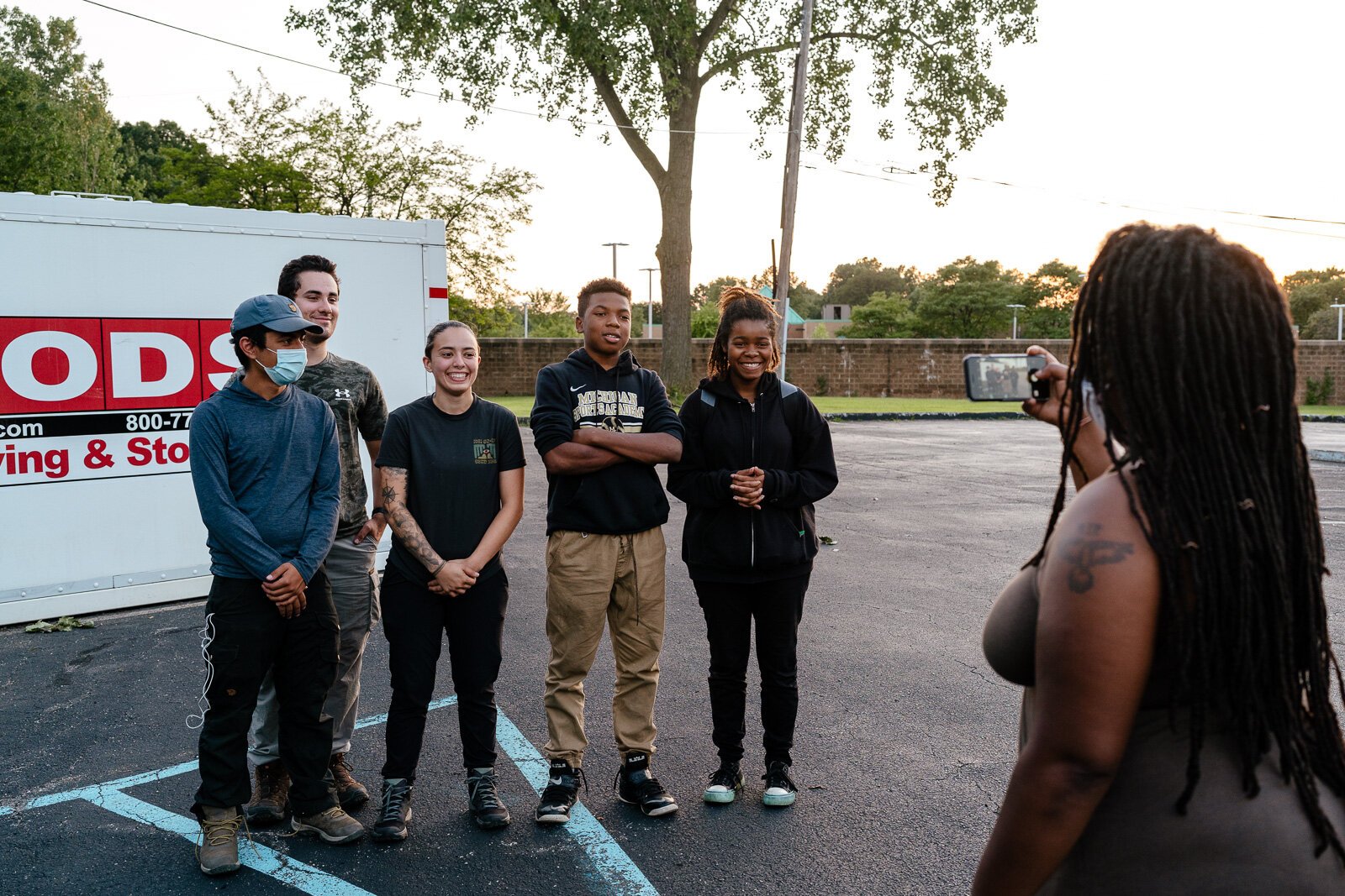 A camper's mom takes a picture of her kids with Detroit Outdoors staff after a camping trip to Pictured Rocks.