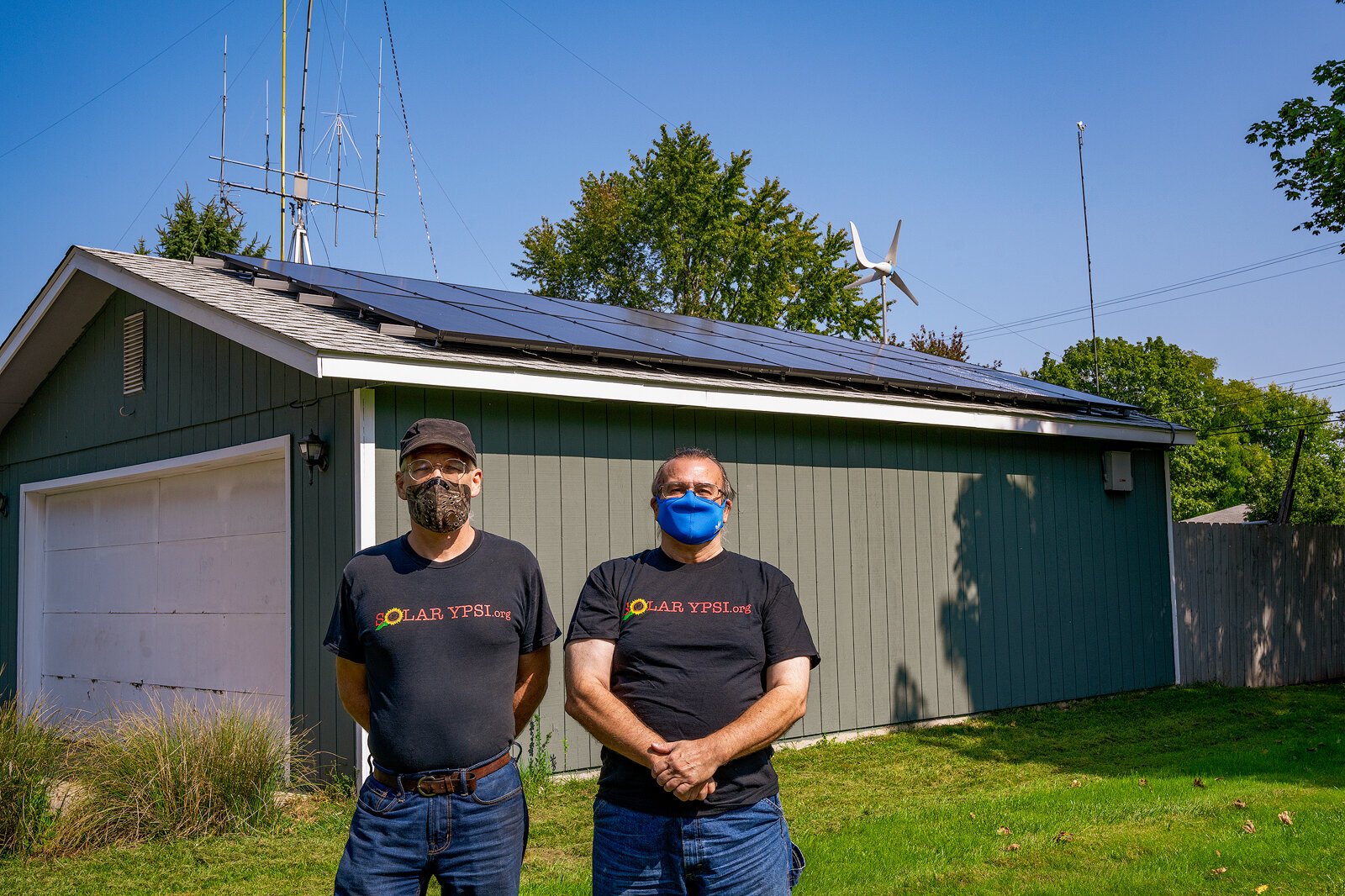 Dave Strenski and Jay Nugent in front of a solar installation on Nugent's Ypsilanti Township home.