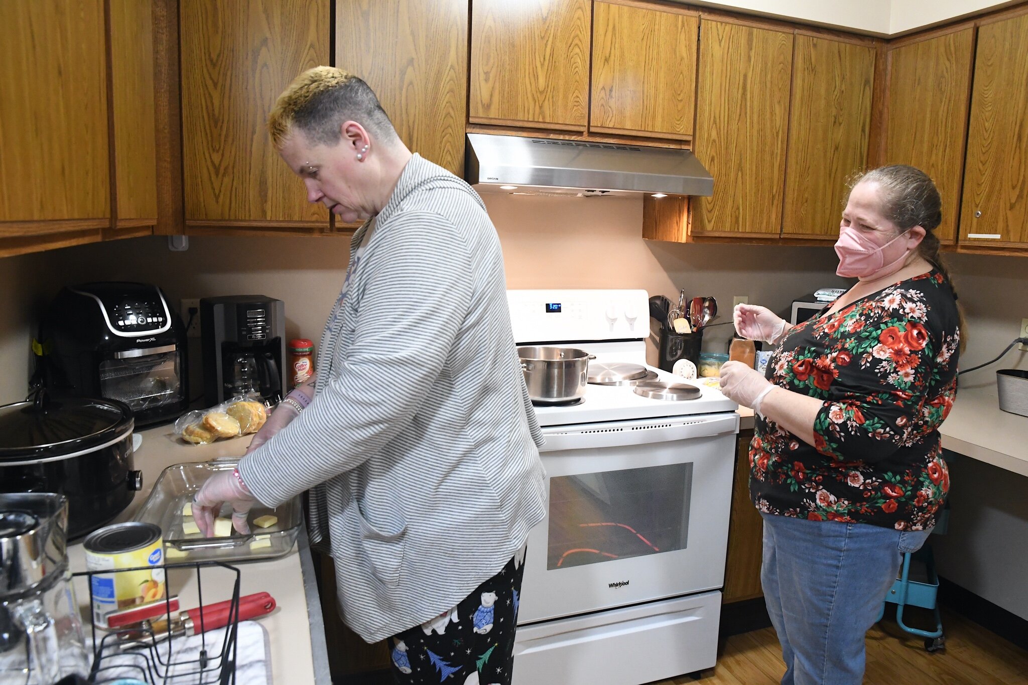 Stacy Jensen, left, Elizabeth Weaver, residential support staff member, prepare peach cobbler.