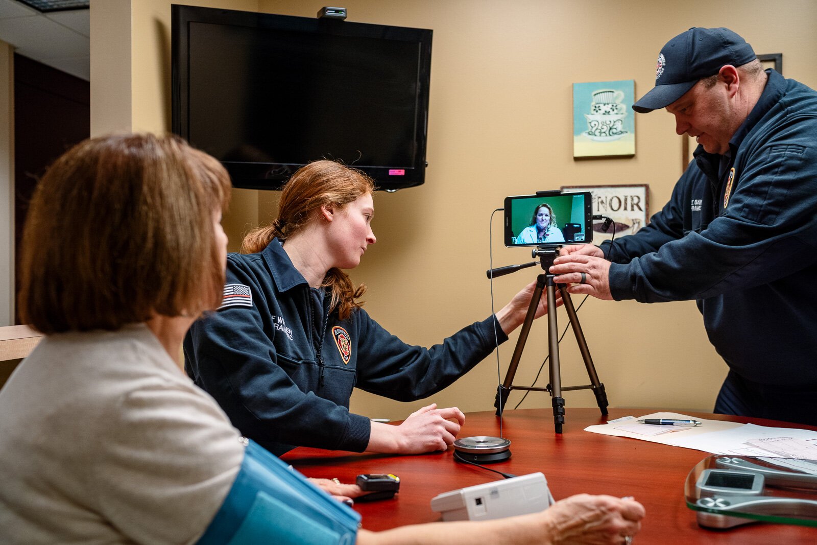 Community integrated paramedics Kim Whalen and Lt. Kevin Bailey of the Bloomfield Township Fire Department conduct a patient visit with Jeri Whitehead (on tablet screen)..