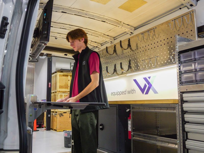 EAVX employee Corbin Fleming-Dittenber demonstrates the versatility and customization of a Ford eTransit upfit with Masterack products and VX technology.