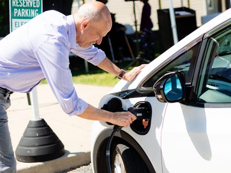 Richard Kosmacher, senior program director, Midwest, Mobility Development Operations, plugs in one of the electric vehicles at a launch event for a new electric vehicle car-share service available at Avalon Housing properties in Ann Arbor.