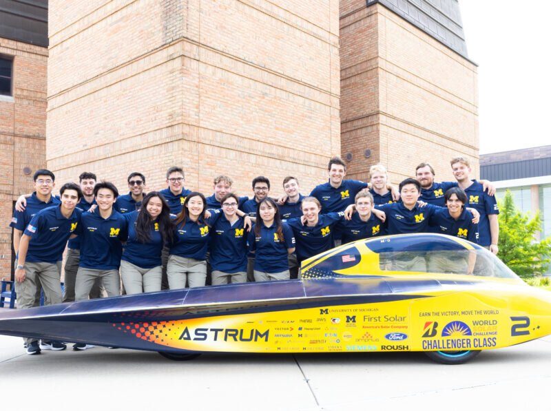 The entire Michigan Solar Car race crew with its 2023 vehicle, Astrum, on the University of Michigan’s North Campus.