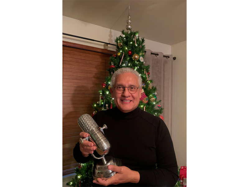 Rudy Alvarado with the trophy he won from the Latin Podcast Awards.