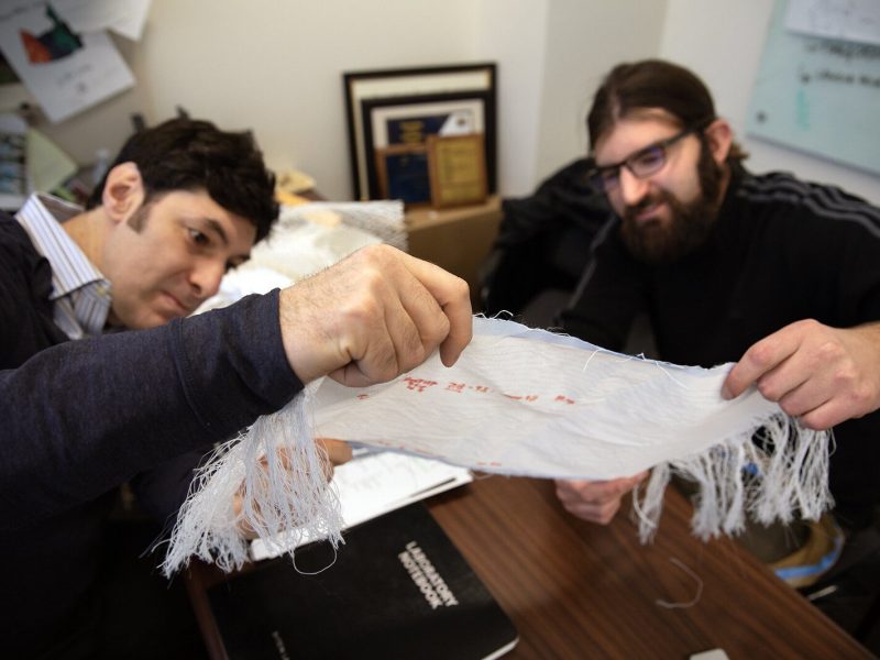 U-M Professor of Materials Science and Engineering Max Stein and Brian Iezzi, post-doctoral researcher at U-M's Materials Science and Engineering Department, analyze fabric with photonic fibers woven into it.