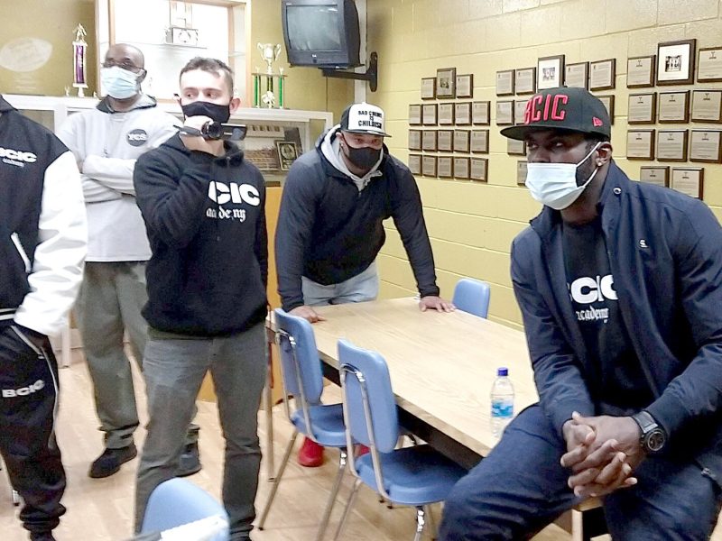 Michael Vick talks to press in the Trophy Room at Ypsilanti Community High School on Dec. 2 before addressing students in the auditorium.
