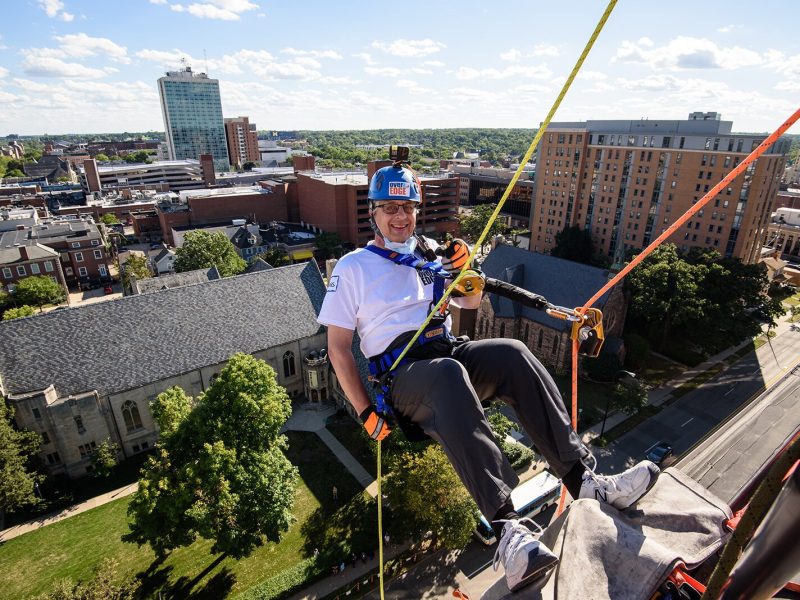 A participant at last year's Over the Edge event prepares to rappel down the Graduate Hotel.