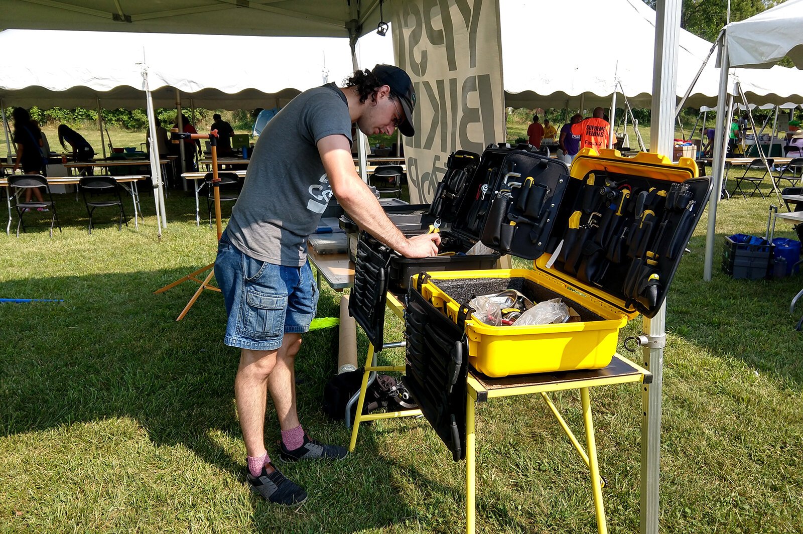 A Ypsi Bike Coop volunteer prepares for a bike clinic and a raffle to give away a refurbished bike during Parkridge SummerFest.