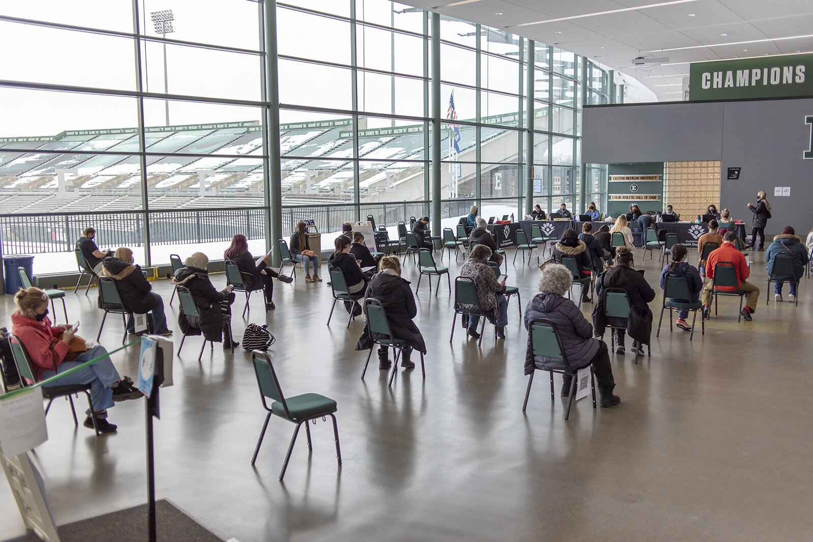 People wait for COVID-19 vaccines at the Eastern Michigan University Convocation Center.