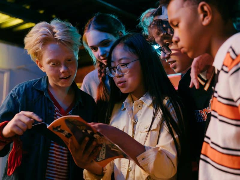 A diverse group of young people reads together.