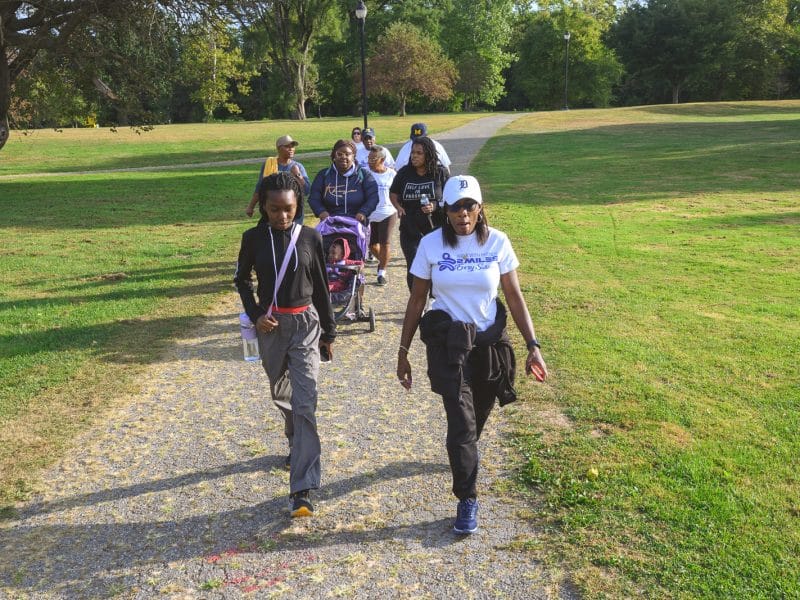 People participate in a group walking event in Ypsilanti.