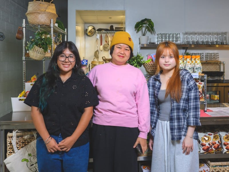 Students Liahni Quijada (left) and Nha Nguyen (right) with Ji Hye Kim (center) at her restaurant, Little Kim. Quijada and Nguyen were among a group of students selected to design a pop-up dinner at Kim's restaurant, Miss Kim, after winning culinary competitions.