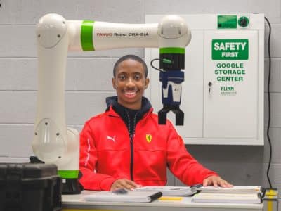 Dylan Presley with a robot arm at Ypsilanti Community High School.
