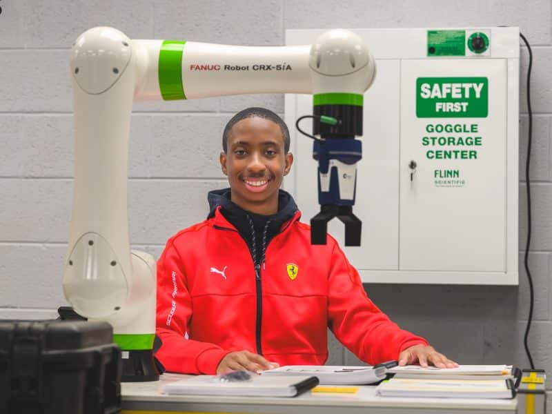 Dylan Presley with a robot arm at Ypsilanti Community High School.