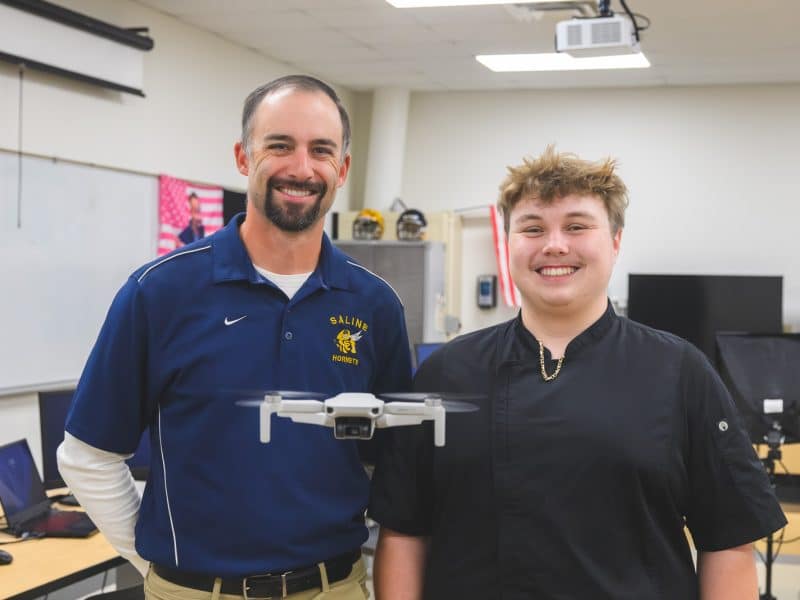Saline High School teacher Corbin Brown and student Dakota Ford with a drone they use in class.