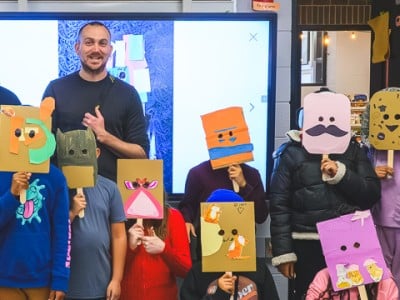 Ypsilanti International Elementary School teacher Gary Quann and Ypsilanti Future History project leader Nick Azzaro (adults in back row) with Quann's class, wearing masks they made in response to the history of an underground venue in Ypsilanti.