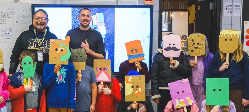 Ypsilanti International Elementary School teacher Gary Quann and Ypsilanti Future History project leader Nick Azzaro (adults in back row) with Quann's class, wearing masks they made in response to the history of an underground venue in Ypsilanti.
