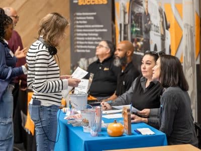 A job seeker talks to employers at a career fair.