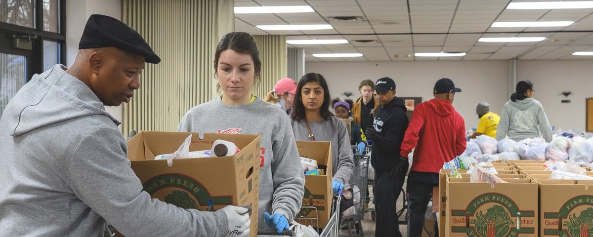 Volunteers line up with shopping carts of food to distribute at the Community Family Life Center in Ypsilanti.