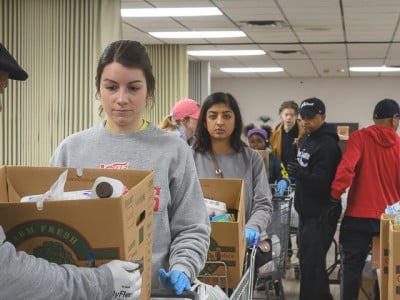 Volunteers line up with shopping carts of food to distribute at the Community Family Life Center in Ypsilanti.