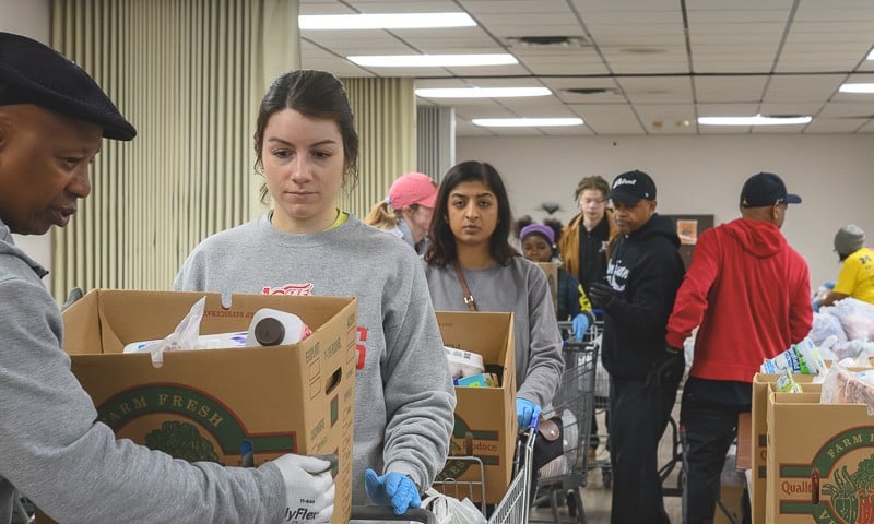 Volunteers line up with shopping carts of food to distribute at the Community Family Life Center in Ypsilanti.