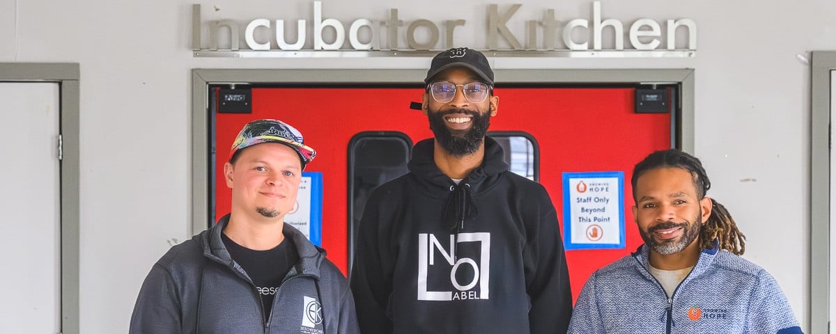 Eric Kinsler-Holloway of EK's Cheesecakes and Brandon Frye of No Label Juice, both "graduates" of the Growing Hope Incubator Kitchen, with Growing Hope Executive Director Julius Buzzard.