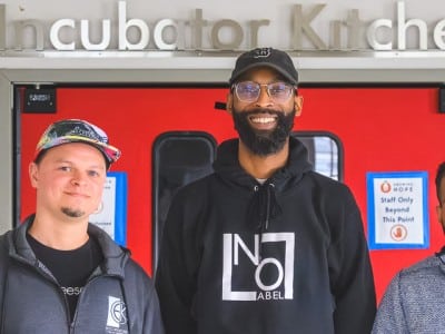 Eric Kinsler-Holloway of EK's Cheesecakes and Brandon Frye of No Label Juice, both "graduates" of the Growing Hope Incubator Kitchen, with Growing Hope Executive Director Julius Buzzard.