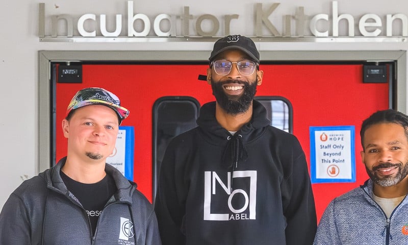 Eric Kinsler-Holloway of EK's Cheesecakes and Brandon Frye of No Label Juice, both "graduates" of the Growing Hope Incubator Kitchen, with Growing Hope Executive Director Julius Buzzard.
