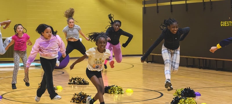 Young people participate in a cheerleading drill organized by Ypsilanti Community - The Village.