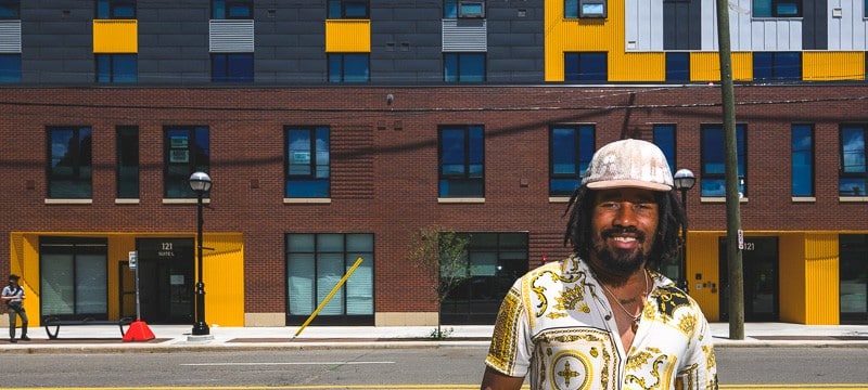 Martez Claybren stands in front of Dunbar Towers in Ann Arbor, where he lives. Dunbar Towers is one of several affordable housing projects supported by the city's Affordable Housing Millage.