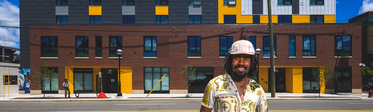 Martez Claybren stands in front of Dunbar Towers in Ann Arbor, where he lives. Dunbar Towers is one of several affordable housing projects supported by the city's Affordable Housing Millage.